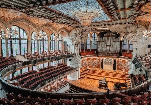 Rijk versierde houten concertzaal met balkons, podium en orgel